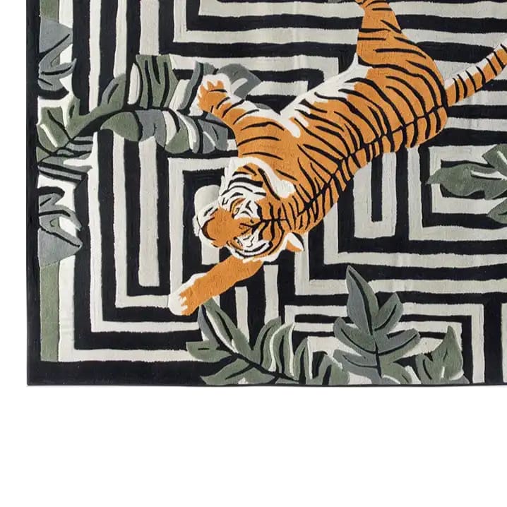 Top view of the Jade Tiger Threshold Hand Tufted Wool Rug, featuring a striking orange tiger design on a black and white geometric pattern, accented with green foliage. This area rug is perfect for adding a bold touch to your living room decor.