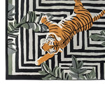 Top view of the Jade Tiger Threshold Hand Tufted Wool Rug, featuring a striking orange tiger design on a black and white geometric pattern, accented with green foliage. This area rug is perfect for adding a bold touch to your living room decor.