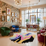 Modern nail salon room with colorful rug, patterned walls, and large windows.