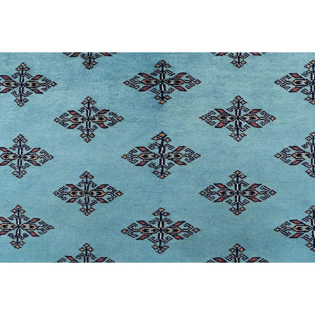 Close-up of the Javarak Blue Hand Knotted Area Rug showcasing its intricate geometric patterns on a soft blue background. Perfect for those seeking elegant area rugs for living room spaces, this large living room rug combines traditional design with modern flair.