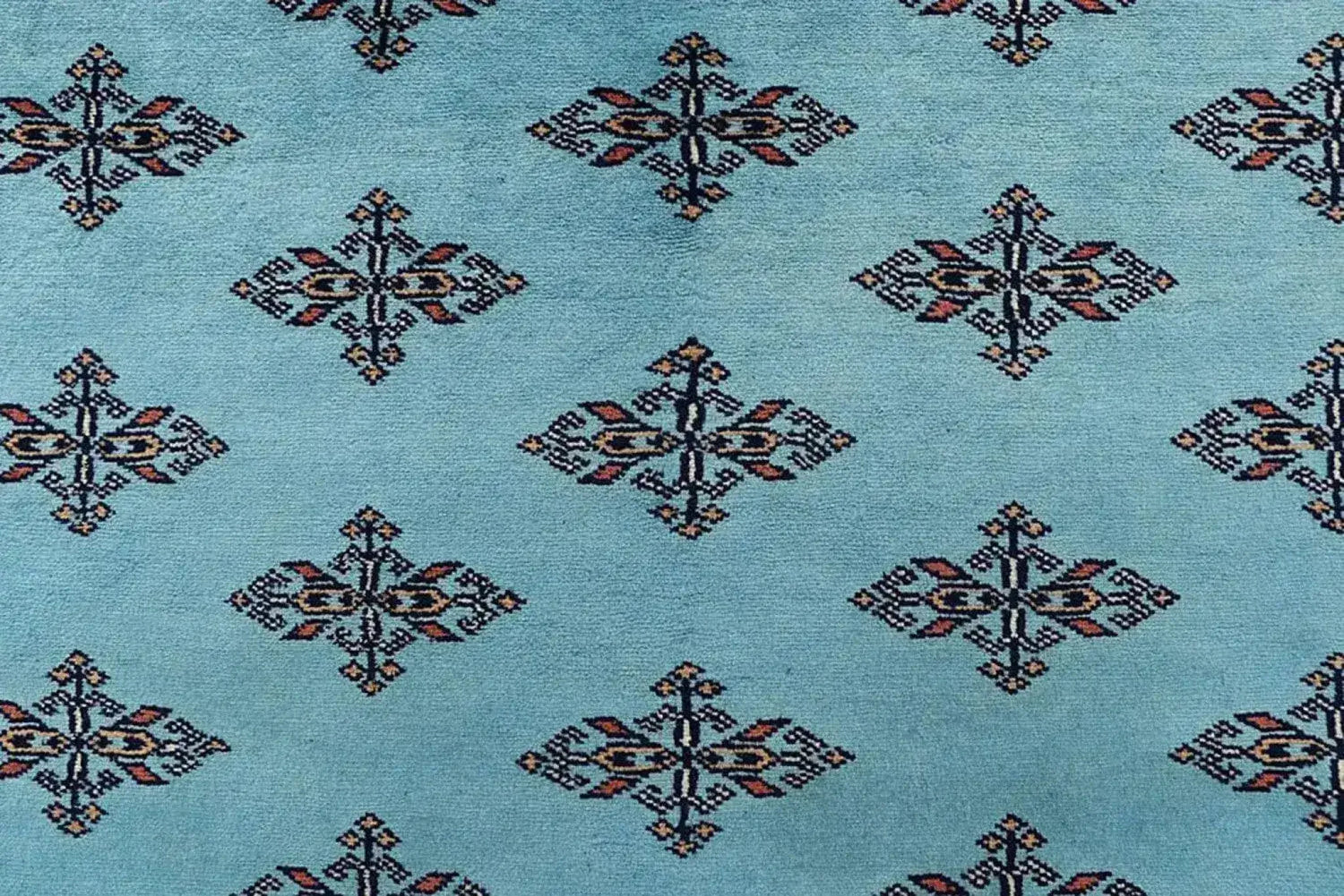 Close-up of the Javarak Blue Hand Knotted Area Rug showcasing its intricate geometric patterns on a soft blue background. Perfect for those seeking elegant area rugs for living room spaces, this large living room rug combines traditional design with modern flair.