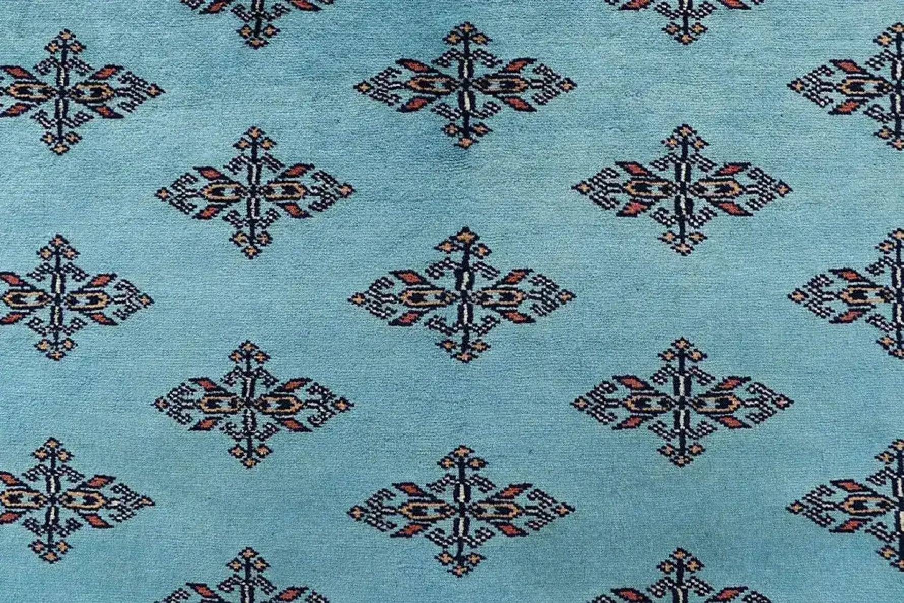 Close-up of the Javarak Blue Hand Knotted Area Rug showcasing its intricate geometric patterns on a soft blue background. Perfect for those seeking elegant area rugs for living room spaces, this large living room rug combines traditional design with modern flair.