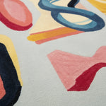 Joy Shape Parade Hand Tufted Area Rug featuring a vibrant abstract design in bold colors, perfect for adding a contemporary touch to your living room. This wool rug showcases a playful mix of shapes in shades of blue, yellow, pink, and red, ideal for modern rugs for living room decor.