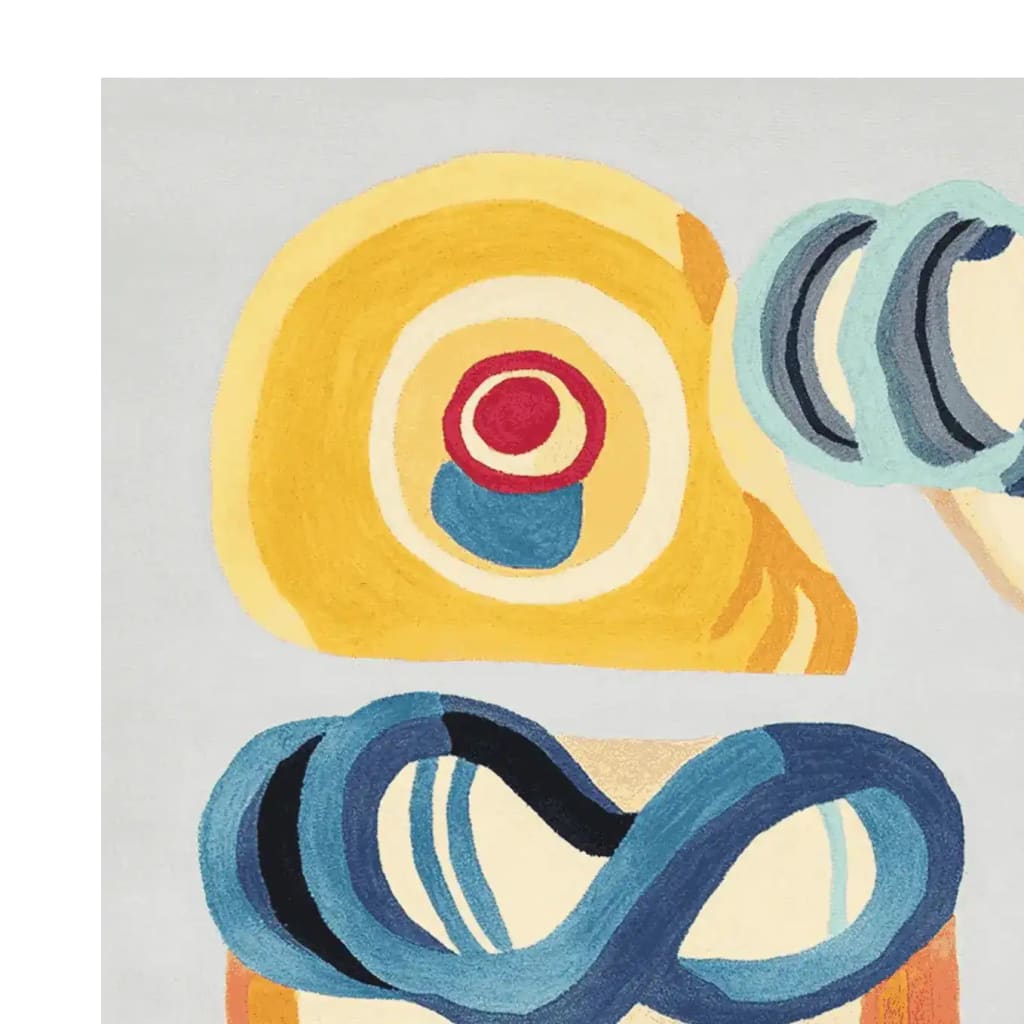 Close-up view of the Joy Shape Parade Hand Tufted Area Rug showcasing its vibrant abstract design. This contemporary wool rug features bold circles and swirls in yellow, blue, and red, making it a striking centerpiece for any living room. Ideal for those looking for unique rugs for living room decor.