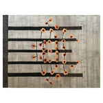 A large contemporary wool rug featuring a unique geometric design with black horizontal lines and orange floral accents against a textured grey background, perfect for enhancing the ambiance of a living room. This area rug blends modern style with the comfort of hand-tufted wool, ideal for those seeking sophisticated area rugs for their living space.