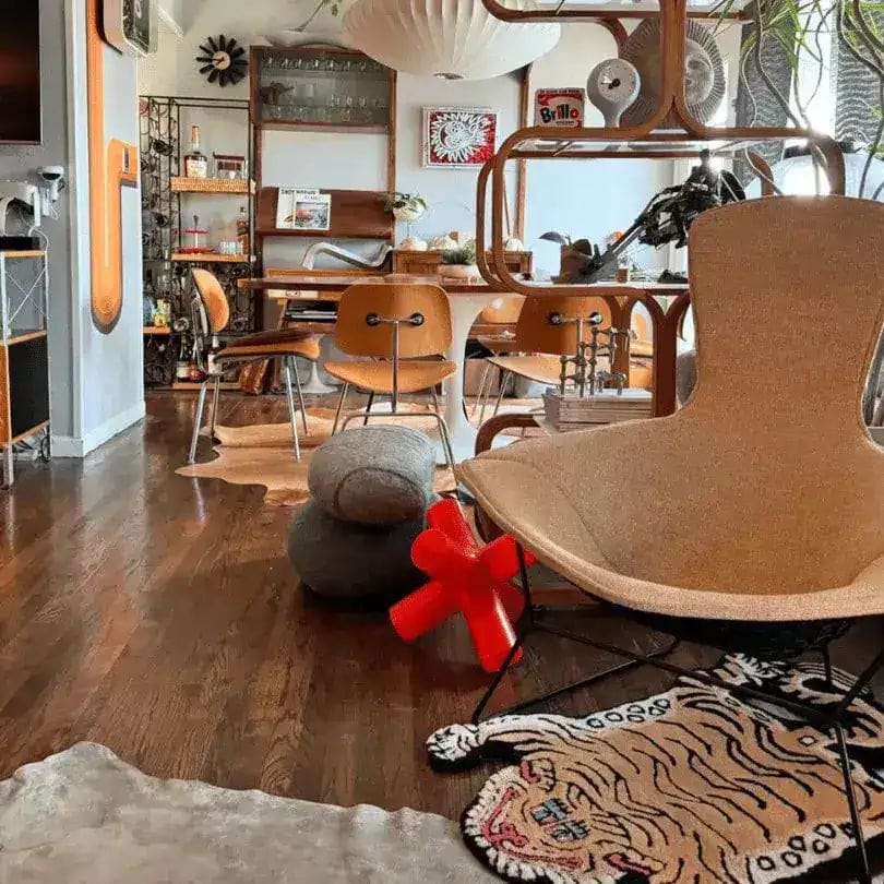 A stylish dining room featuring a hand tufted wool area rug with a playful tiger design. The rug adds a touch of whimsy to the modern furniture and decor, making it a perfect fit for both living room and dining room settings.