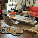 A stylish living room featuring an abstract tiger design area rug made from hand-tufted wool. The unique wool rug adds a playful yet sophisticated touch to the space, complementing the modern decor with a mix of vintage and contemporary furniture. Ideal for both living room and dining room settings, this area rug enhances the room's aesthetic appeal.