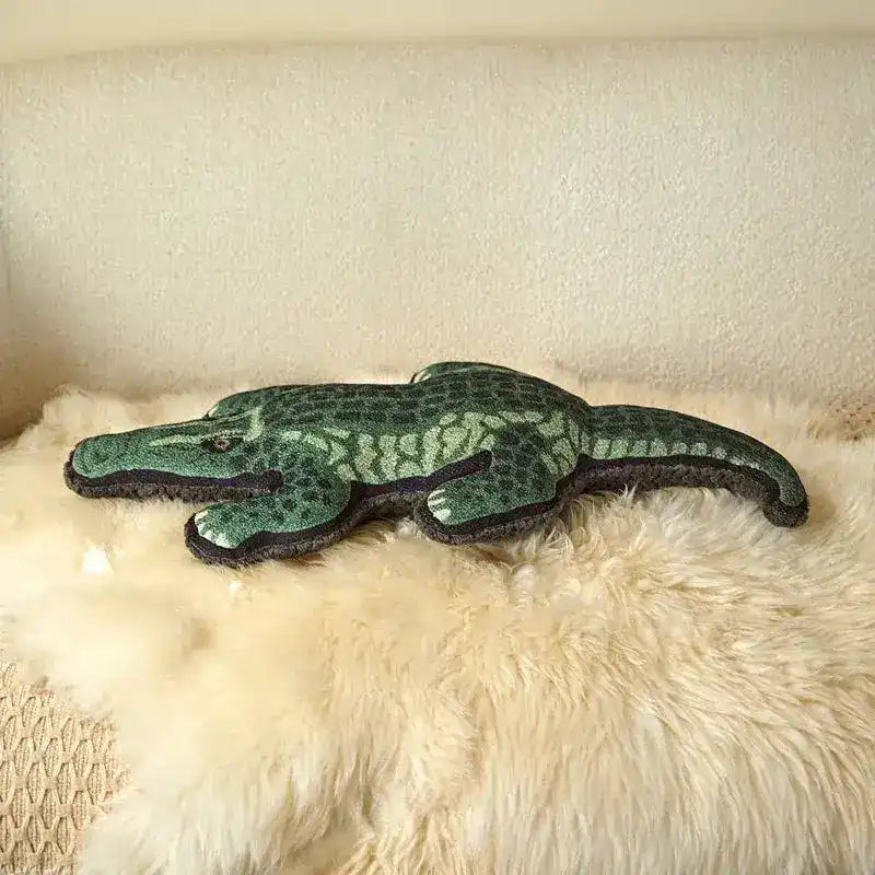 Unique throw pillow shaped like a crocodile, featuring realistic green scales, perfect for adding a wild touch to your home decor.