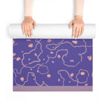 Hands unrolling the Lavender Dreams Yoga Mat, purple mat with pink dots and grey swirls