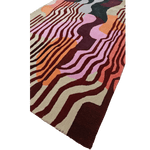 Colorful abstract patterned rug on a green background