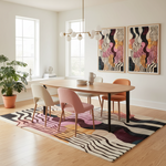Modern dining room with a wooden table and colorful chairs on a patterned rug.