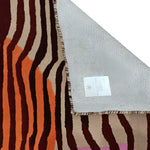 Close-up view of a Layered Abstract Hand Tufted Area Rug, perfect for living room decor. This contemporary wool rug features bold, wavy stripes in rich orange and brown tones, ideal for adding a modern touch to area rugs for living room settings.