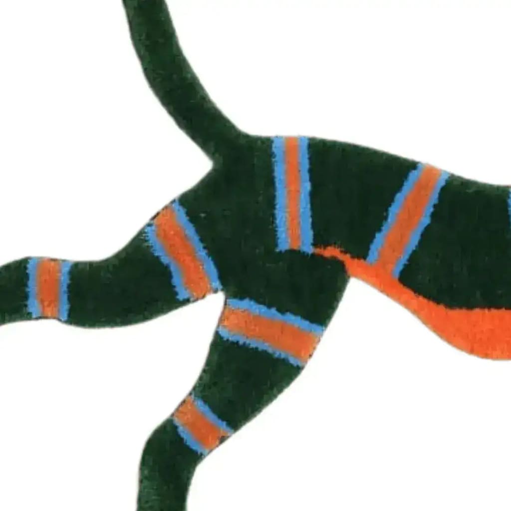 Close-up view of the Leaping Monkey Hanuman Accent Wool Rug featuring vibrant orange and blue stripes on a dark green background. Perfect for adding a touch of vintage charm to dining rooms or bedrooms, this wool rug is ideal for formal dining room settings or as a cozy addition to bedroom decor.