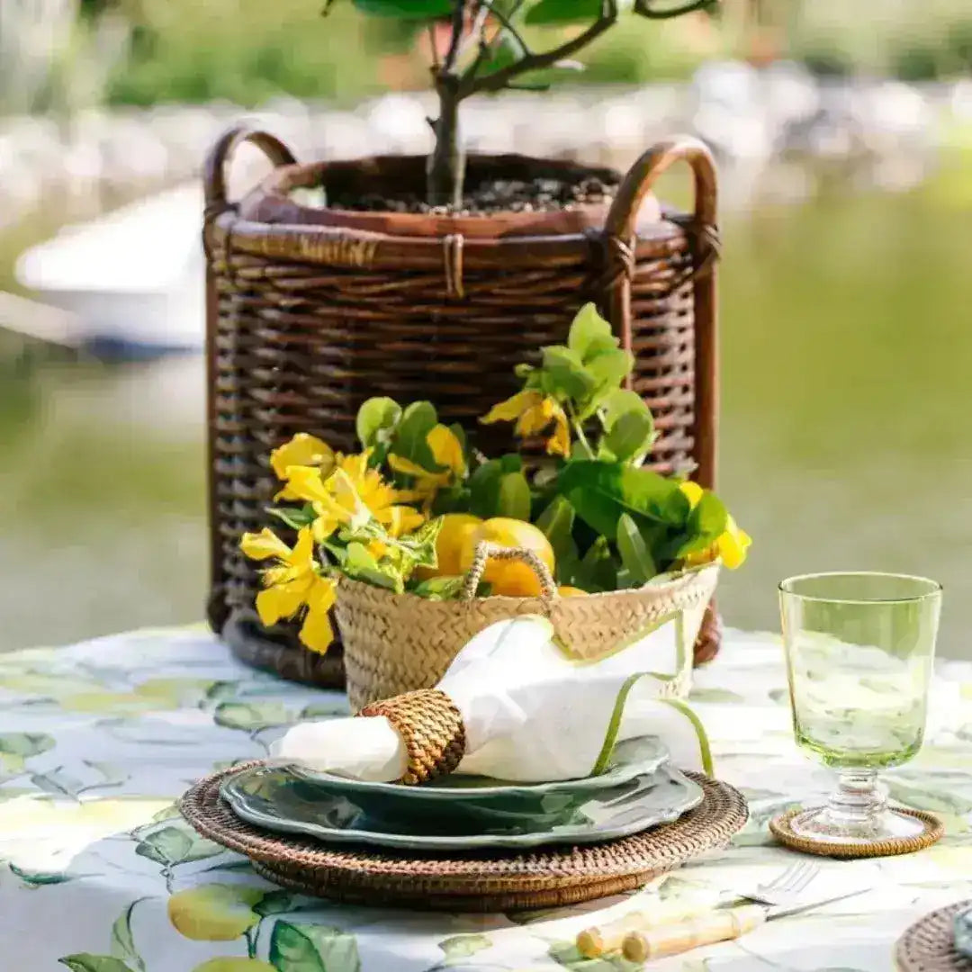 lemonade love placemat rattan round outdoor table green plates white napkin green glass wicker basket lemon tree waterfront