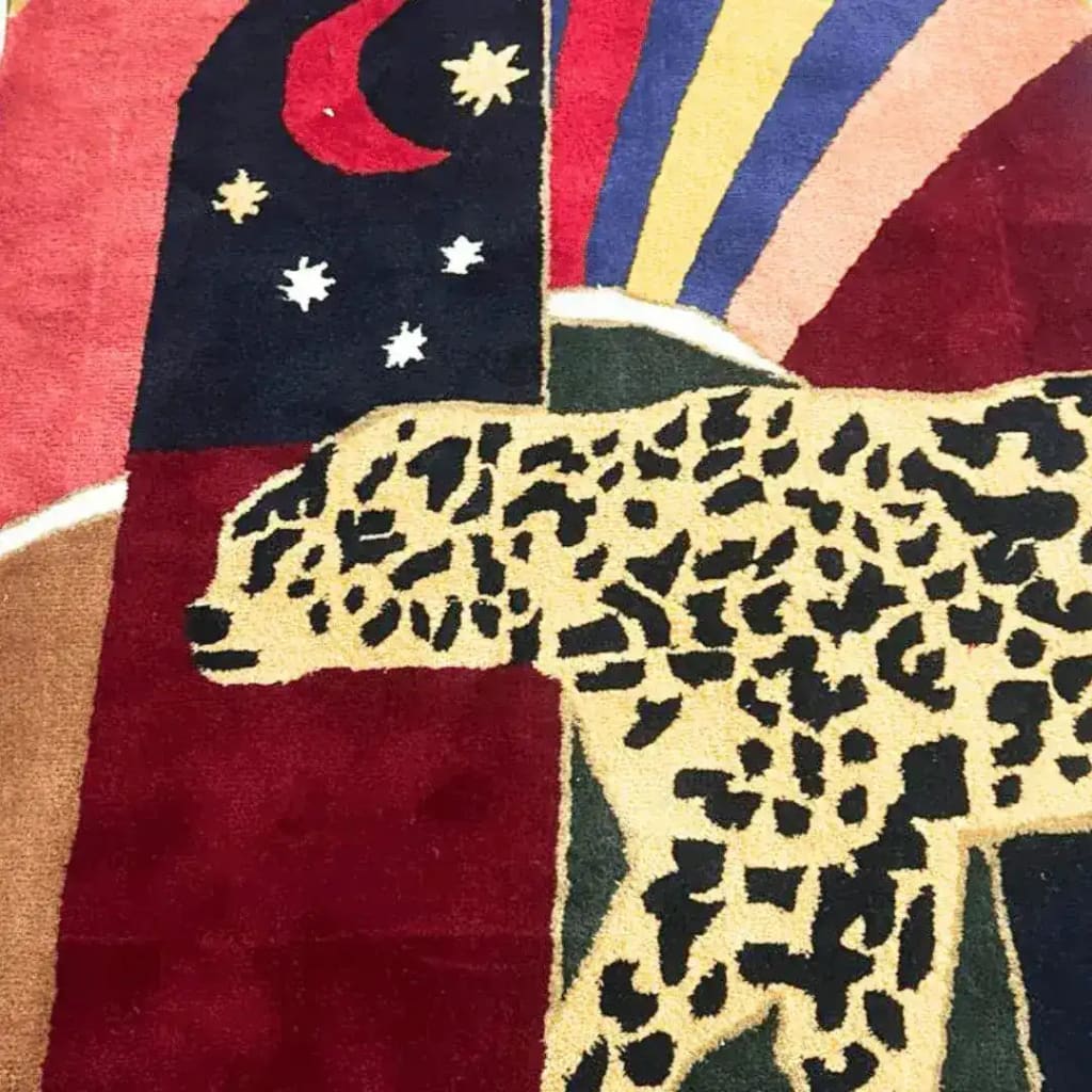 Close-up view of the Leopard Crossing the Sun Hand-Tufted Area Rug in red, showcasing its intricate design with a leopard and celestial motifs. Perfect for adding a bold touch to formal dining room rugs or dining room carpets, this wool rug combines artistry with quality.