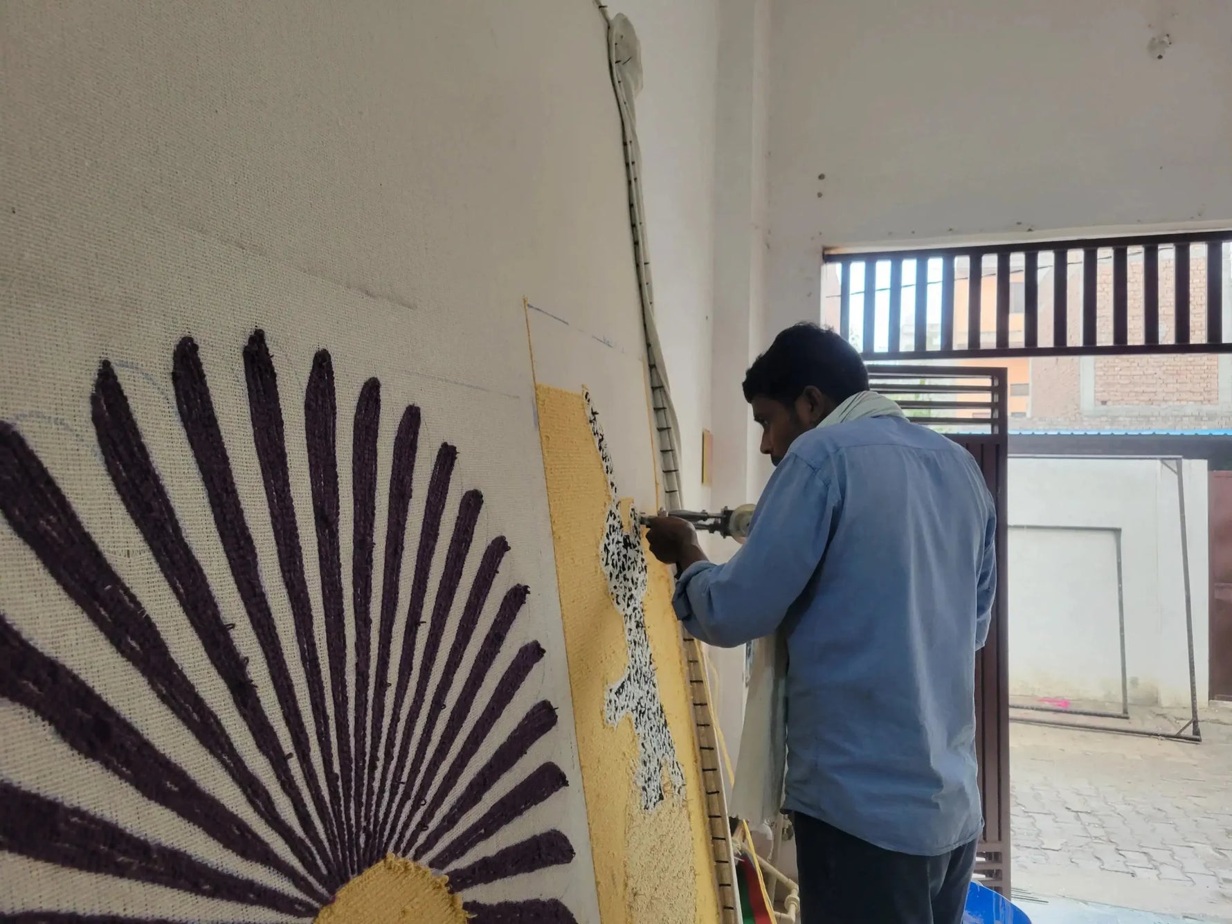 A skilled artisan meticulously crafting the 'Leopards on Silk Road Tufted Wool Rug Runner'. This area rug, perfect for spaces like the dining room, kitchen, or as a hallway runner rug, showcases intricate leopard designs on quality wool. Ideal for those seeking kitchen runner rugs or bathroom runner rugs to elevate their home decor.