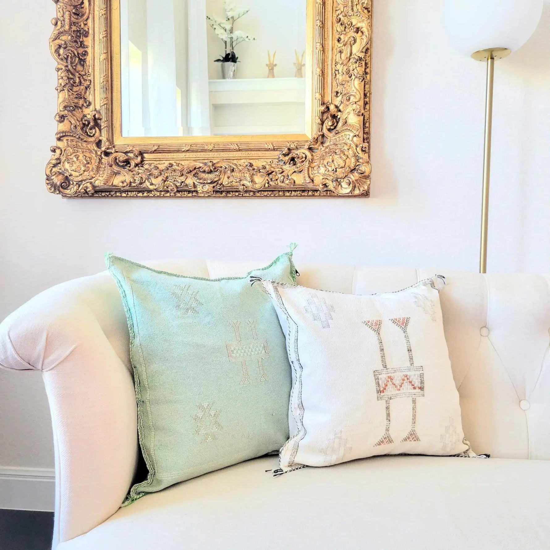 Light green handwoven cactus silk throw pillow cover on a white couch, paired with a decorative white pillow, enhancing a stylish living room decor.