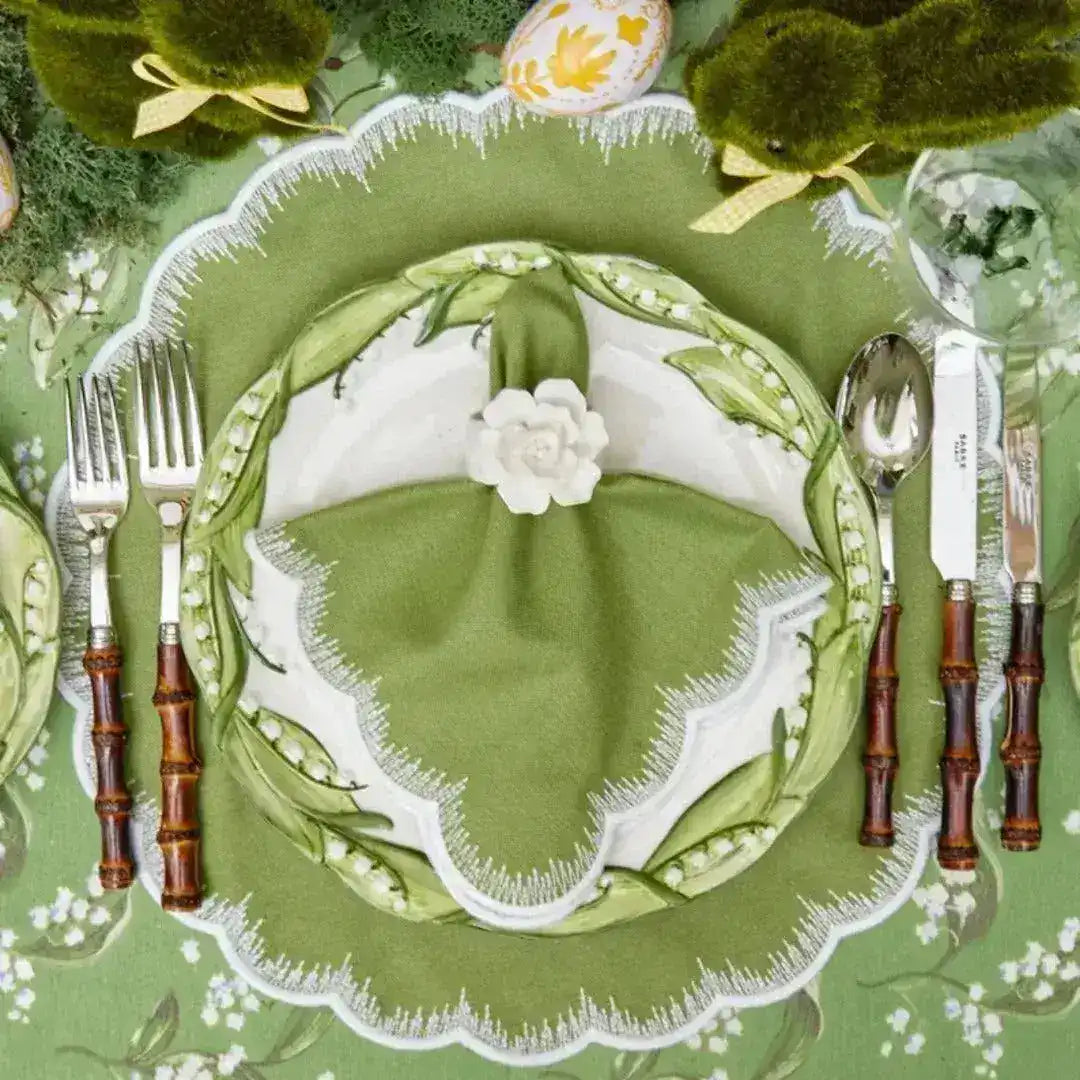 Lily of the Valley Elegance placemat at table setting with floral-rim china, green napkin, white flower ring, bamboo silverware