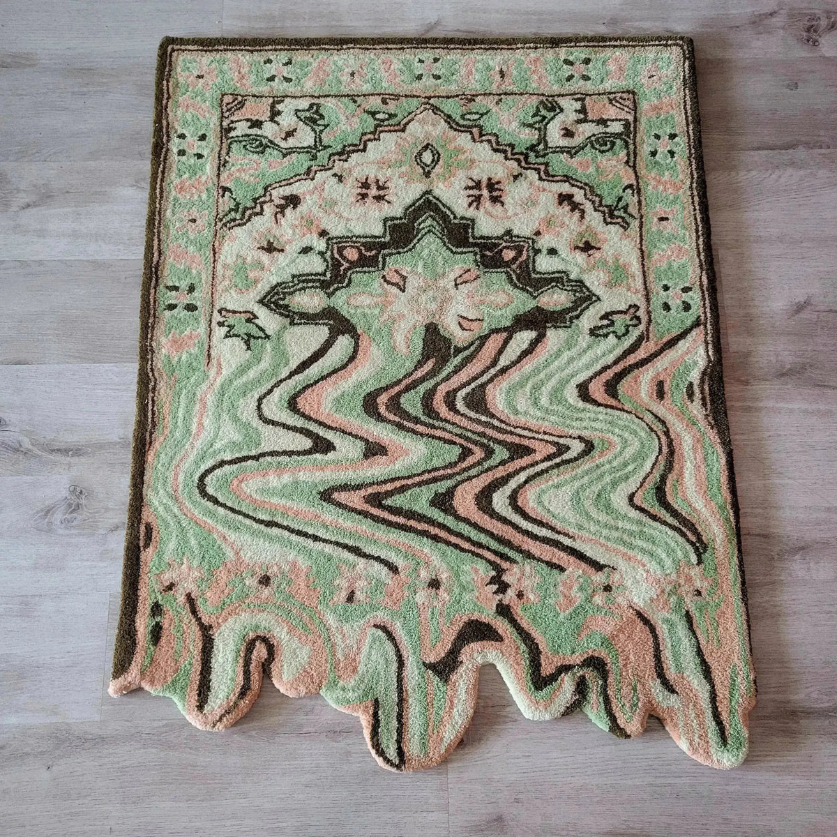 A vibrant Lime Green Melting Traditional Persian Hand Tufted Wool Rug displayed on a wooden floor. This abstract area rug features a blend of green, peach, and brown tones, ideal for enhancing dining rooms or living room spaces with its unique design.