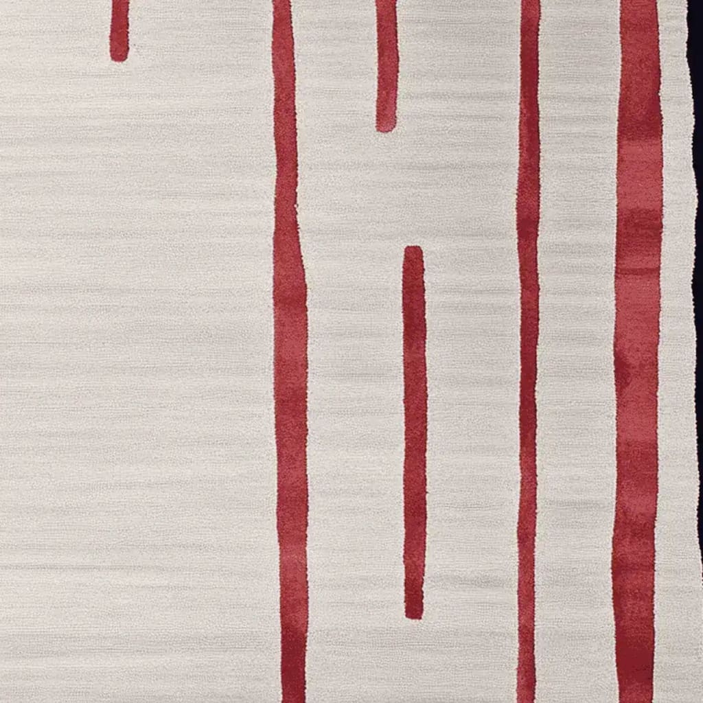 Close-up of a contemporary wool area rug featuring bold red linear patterns on a soft beige background, perfect for adding modern elegance to living room spaces.