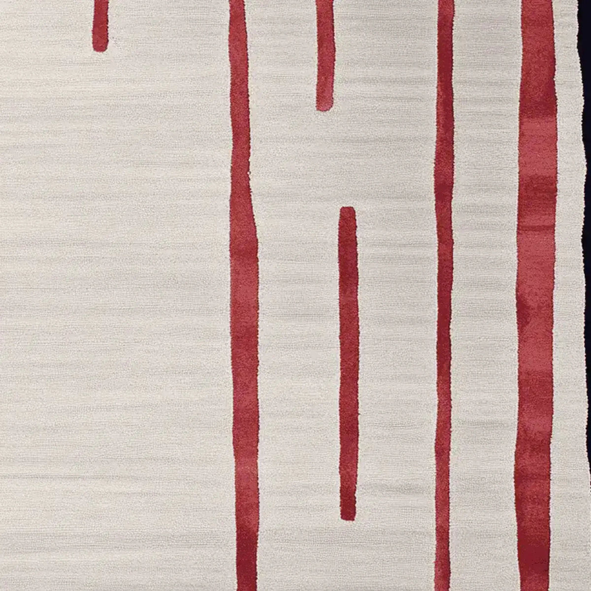 Close-up of a contemporary wool area rug featuring bold red linear patterns on a soft beige background, perfect for adding modern elegance to living room spaces.