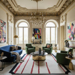 Luxurious living room with ornate ceiling, colorful artwork, and modern furniture.