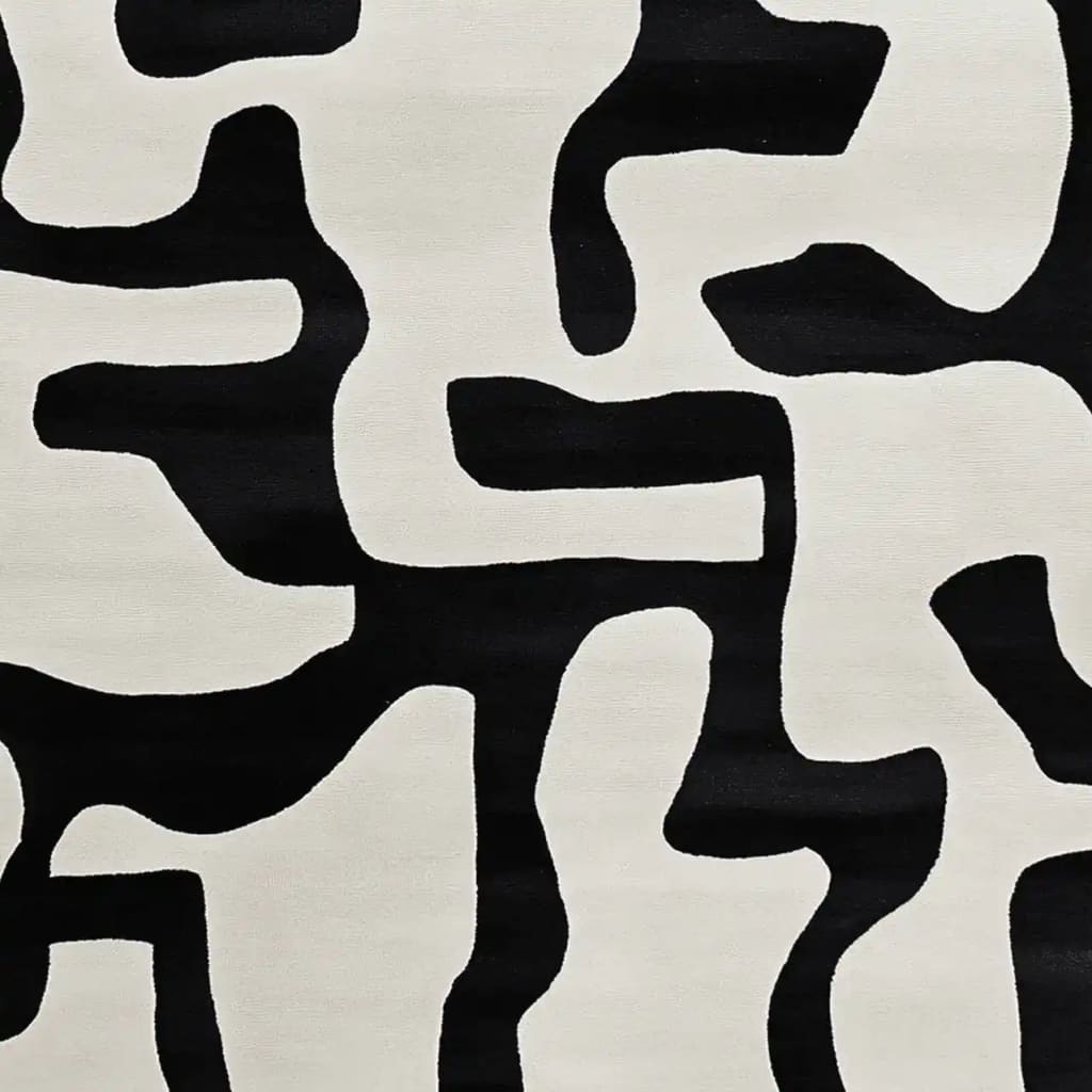 Contemporary area rug featuring an abstract black and white design, perfect for modern living room decor. This wool rug showcases bold, irregular shapes, making it an eye-catching piece among living room area rugs.