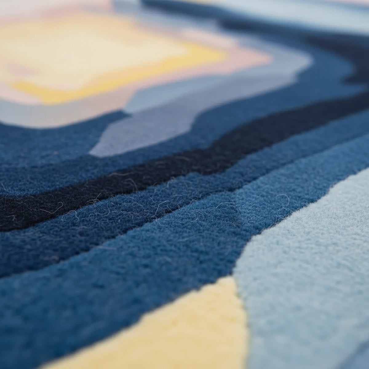 Close-up of a textured rug with blue, yellow, and black colors.