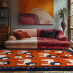 A vibrant Lion's Parade Hand Tufted Area Rug with playful lion motifs in an elegant dining room setting. The wool rug, perfect as a dining table rug or dining room carpet, adds a splash of color with its rich orange and contrasting blue border, enhancing the cozy ambiance of the space.
