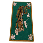 A vibrant hand-tufted wool area rug featuring an abstract tiger design set against a rich green background. Perfect for adding a touch of boho style to dining room carpets or as a centerpiece in living room and dining room rugs. The large area rug showcases elegant lotus flowers, making it a stylish addition to any space.