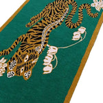 Top view of a vibrant green area rug featuring an abstract design of an Indian tiger surrounded by lotus flowers. This hand-tufted wool rug is perfect for adding a boho touch to dining room carpets or as a striking centerpiece in living room and dining room rugs.