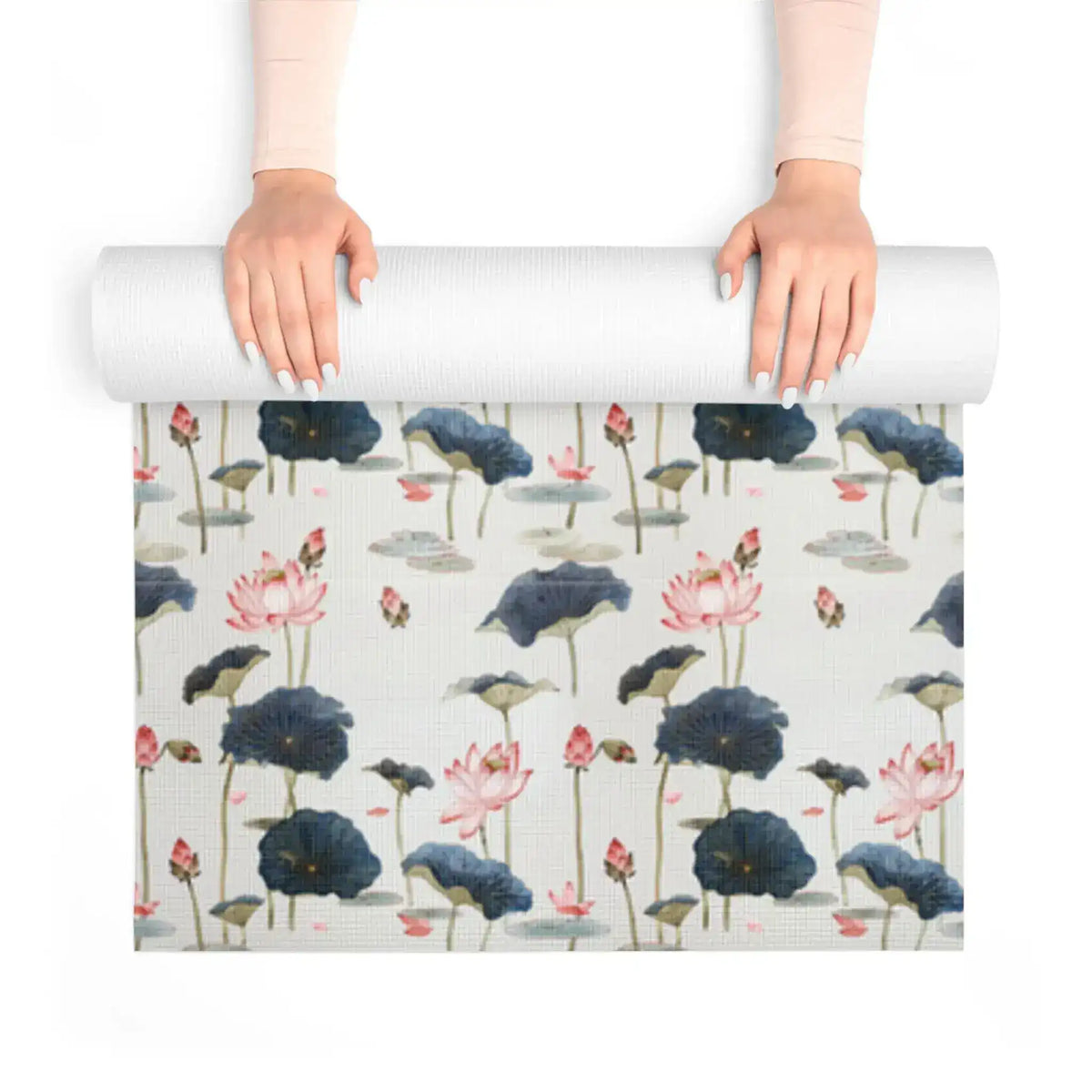 Hands unrolling Lotus Reflection yoga mat showing detailed pink lotus flowers and inky lily pads