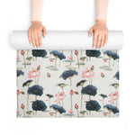 Hands unrolling Lotus Reflection yoga mat showing detailed pink lotus flowers and inky lily pads