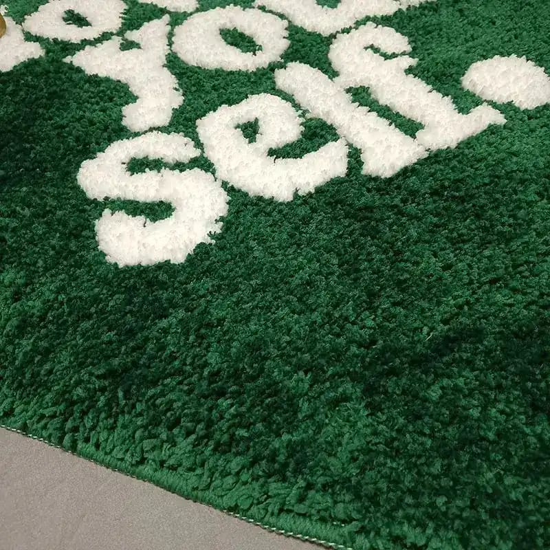 Close-up of a plush green area rug with the phrase 'Love Your Self' in white letters, perfect for adding a cozy touch to living room decor. Ideal for those seeking stylish area rugs for living room settings.