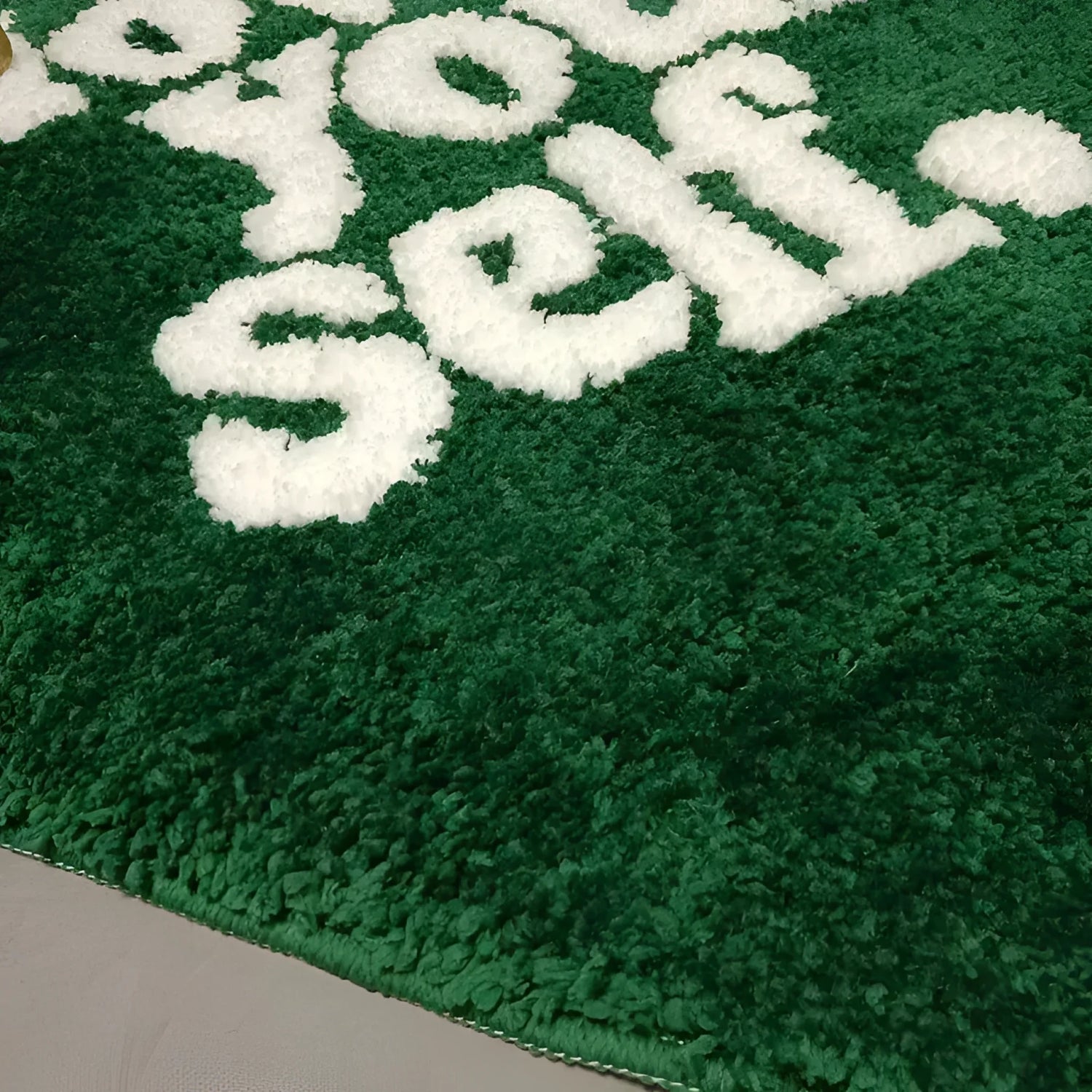Close-up of a plush green area rug with the phrase 'Love Your Self' in white letters, perfect for adding a cozy touch to living room decor. Ideal for those seeking stylish area rugs for living room settings.