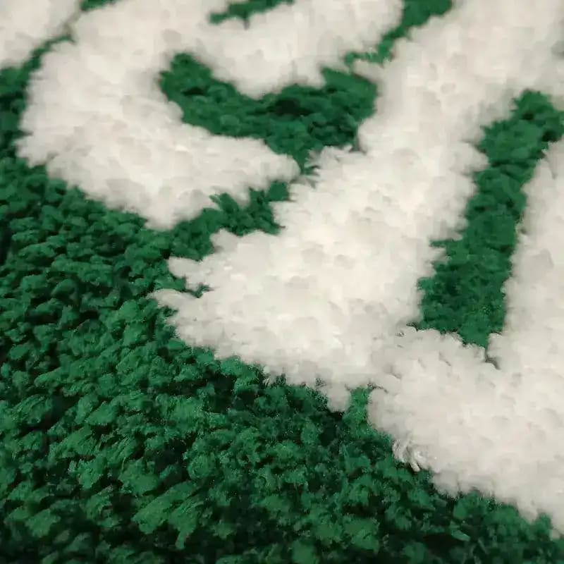 Close-up of a plush green and white heart-shaped bath area rug, perfect for adding a cozy touch to your living room. This rug is ideal for those looking for stylish area rugs for living room decor.