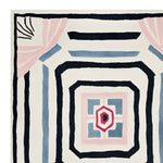 Top view of the Lucid Growth Totem Hand Tufted Area Rug, showcasing its bold abstract design in black, blue, pink, and cream colors. This contemporary wool rug offers a unique centerpiece for area rugs in living rooms.