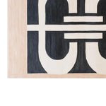 Close-up view of the Lunar Cascade Knotted Wool Rug showcasing its bold, abstract black and white geometric design. This contemporary rug, made from high-quality wool, is perfect for adding a modern touch to living room spaces. Ideal as a centerpiece among area rugs, it brings both style and comfort to any home.