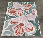 Floral patterned rug with pink flowers on a gray background