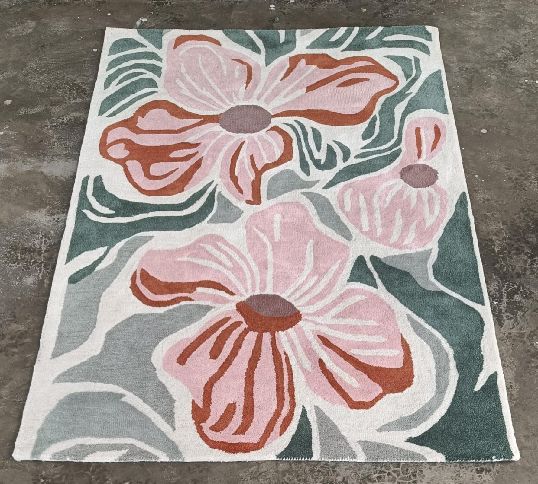 Floral patterned rug with pink flowers on a gray background