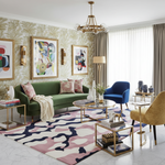 Modern living room with a green sofa, colorful rug, and decorative wall art.