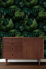 Lush green fern jungle wallpaper behind a mid-century walnut sideboard