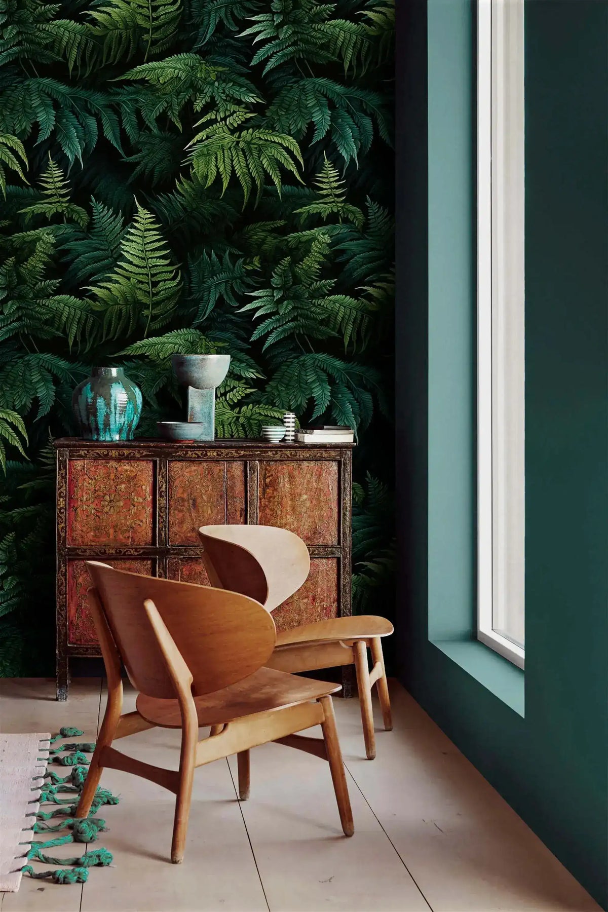 Lush green fern jungle wallpaper in corner with carved wood cabinet, teal vases and wood chair