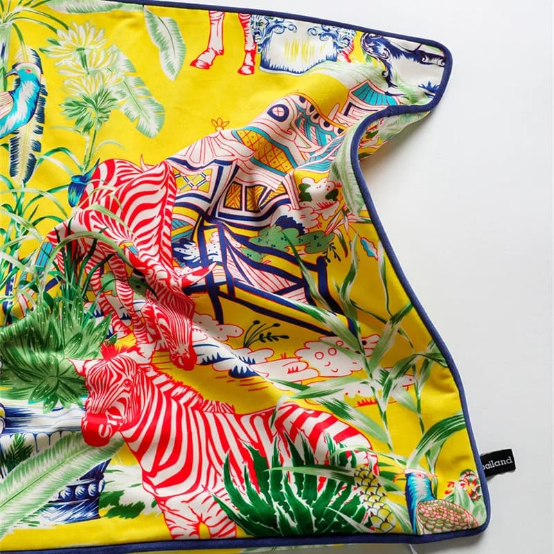 Luxurious throw pillow featuring vibrant lemon yellow fabric adorned with exotic zebra and tropical patterns, perfect for adding a pop of color to any space.