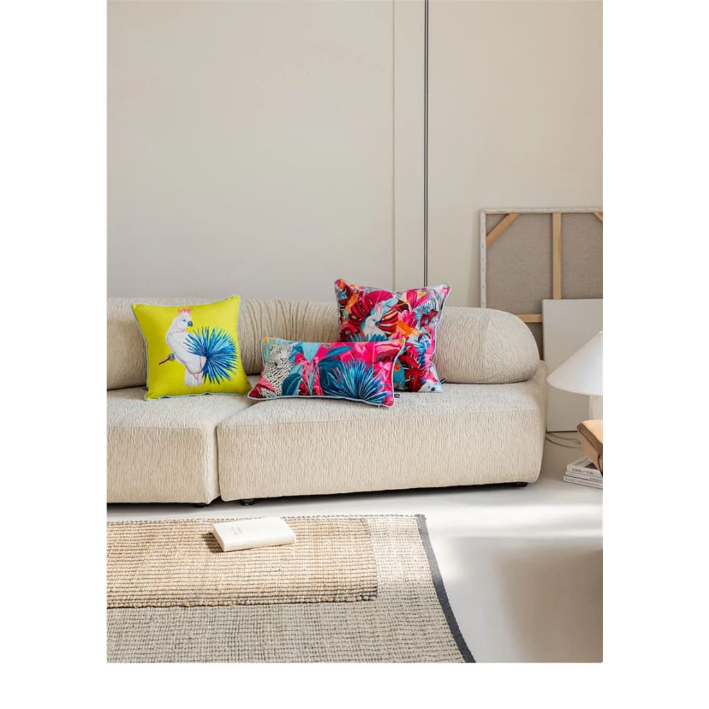 Colorful throw pillows featuring tropical designs on a light sofa, ideal for adding a vibrant accent to any living space.