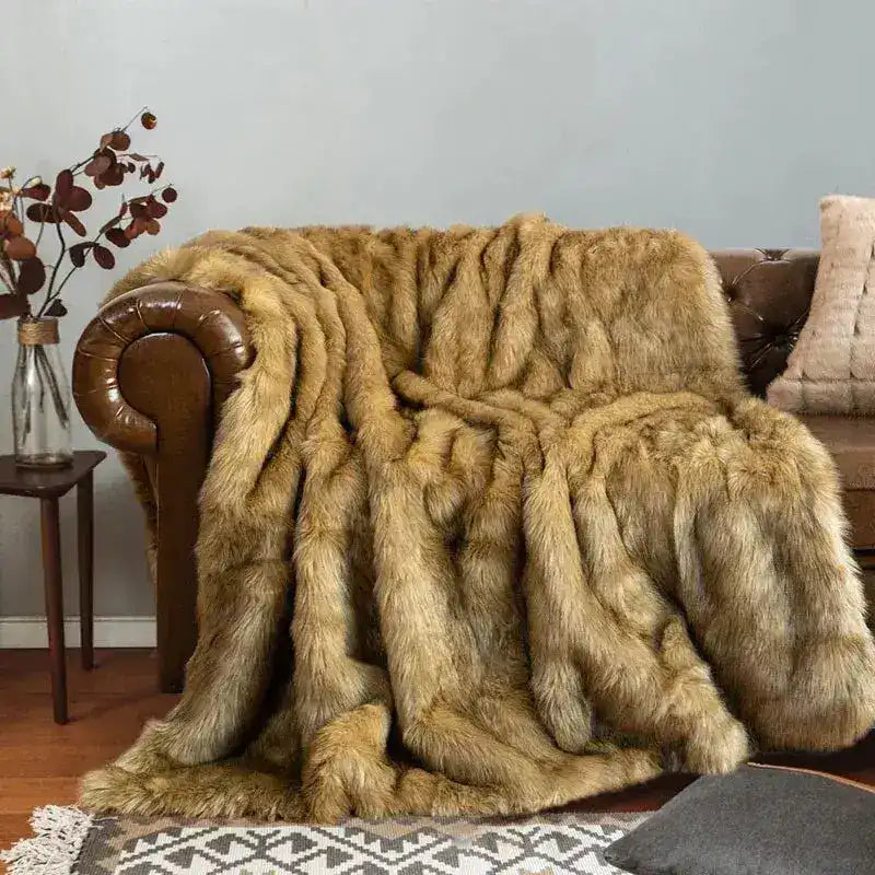 Luxury Faux Fur Blanket in warm golden-brown draped over leather Chesterfield sofa, long striped fur pile, cozy in-home setting