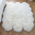 A luxurious plush soft sheepskin area rug displayed in a cozy living room setting. This large living room rug, ideal for an 8x10 space, features a fluffy white texture that adds warmth and elegance to the hardwood floor.