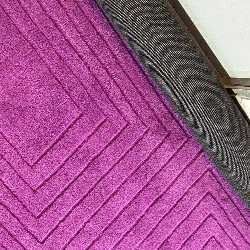 Close-up of the Magenta Artic Geo Modern Hand Tufted Wool Rug showcasing its vibrant geometric pattern. Ideal for a contemporary dining room, this wool rug adds a pop of color and style to any formal dining room setting. Perfect for those looking for large area rugs or dining room carpets.