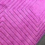 Close-up view of the Magenta Artic Geo Modern Hand Tufted Wool Rug, showcasing its bold geometric pattern. Perfect for a contemporary dining room, this large area rug adds a vibrant touch to formal dining room settings. Made from high-quality wool, it serves as an elegant dining room carpet.