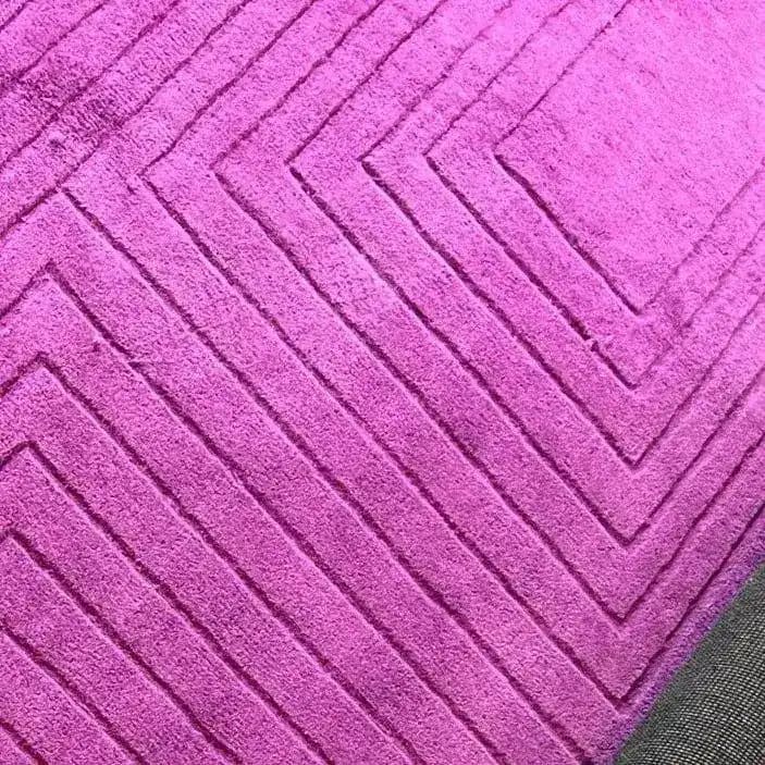 Close-up view of the Magenta Artic Geo Modern Hand Tufted Wool Rug, showcasing its bold geometric pattern. Perfect for a contemporary dining room, this large area rug adds a vibrant touch to formal dining room settings. Made from high-quality wool, it serves as an elegant dining room carpet.
